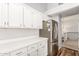 Kitchen with white cabinets, stainless refrigerator, and quartz countertops at 617 N Cobblestone St, Gilbert, AZ 85234