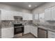 Updated kitchen showcasing white cabinets, granite counters, stainless appliances, and ample natural light at 625 N Hamilton St # 36, Chandler, AZ 85225