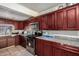 Kitchen features dark wood cabinets, stainless steel appliances, tile flooring and generous countertop space at 637 W Atlanta Ave, Phoenix, AZ 85041