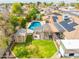 Aerial view of home with a sparkling blue swimming pool, covered patio, shed, and lush greenery at 6409 W Riviera Dr, Glendale, AZ 85304