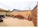 Concrete residential backyard with firewood pile, storage containers, and a fence, offering a glimpse into the outdoor space at 6409 W Riviera Dr, Glendale, AZ 85304