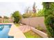 Landscaped backyard with a pool, tiled area, and lush greenery at 6409 W Riviera Dr, Glendale, AZ 85304