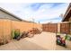 Concrete backyard featuring firewood pile, gardening equipment, a fence, and a tool, revealing the outdoor area at 6409 W Riviera Dr, Glendale, AZ 85304