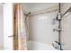 A clean bathroom showcasing a bathtub with tiled walls and a shower head at 6409 W Riviera Dr, Glendale, AZ 85304