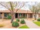 Charming single-story brick home features well-manicured landscaping, mature trees, and a welcoming walkway at 6409 W Riviera Dr, Glendale, AZ 85304