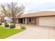 Charming single-story brick home features well-manicured landscaping, mature trees, and a welcoming walkway at 6409 W Riviera Dr, Glendale, AZ 85304