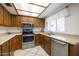 Well-lit kitchen with wood cabinets, stainless steel appliances, and neutral countertops offers practicality and timeless appeal at 6409 W Riviera Dr, Glendale, AZ 85304