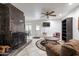 Spacious living room with a fireplace, ceiling fan, and tile flooring, perfect for gatherings or quiet evenings at 6409 W Riviera Dr, Glendale, AZ 85304