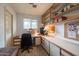 A clean home office featuring a built-in desk and shelving, with a window providing natural light at 6409 W Riviera Dr, Glendale, AZ 85304