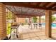 Inviting covered patio with grill, dining set, and pool view for outdoor living at 6409 W Riviera Dr, Glendale, AZ 85304