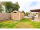 Backyard featuring a storage shed, pool, and covered patio area at 6409 W Riviera Dr, Glendale, AZ 85304