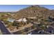 Aerial view of community pool, clubhouse, parking, and desert landscaping with mountain backdrop at 7603 E Soaring Eagle Way, Scottsdale, AZ 85266