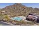 Aerial view of community pool area featuring ample lounge chairs and stunning mountain views at 7603 E Soaring Eagle Way, Scottsdale, AZ 85266