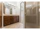 Bathroom with a tiled vanity, mirror, and framed glass shower with tan colored tiles at 7603 E Soaring Eagle Way, Scottsdale, AZ 85266