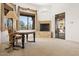 Open room with a fireplace, an adjacent office area, and a glass door to the exterior at 7603 E Soaring Eagle Way, Scottsdale, AZ 85266
