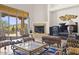 Bright living room features fireplace, large windows with outdoor views, and sophisticated seating arrangement at 7603 E Soaring Eagle Way, Scottsdale, AZ 85266