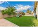 A wood playset sits on grass in this spacious backyard at 7605 W Avalon Dr, Phoenix, AZ 85033