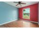 Bedroom featuring a ceiling fan, wood floors and a view of the front yard at 7605 W Avalon Dr, Phoenix, AZ 85033