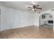 Spacious living room with tile floors, a ceiling fan, and a view of the connecting archway at 7605 W Avalon Dr, Phoenix, AZ 85033