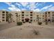 Full exterior shot of a multi-story apartment building with mature landscaping and red awnings at 7860 E Camelback Rd # 309, Scottsdale, AZ 85251