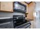 Close-up of a kitchen showcasing stainless steel appliances and dark granite countertops at 7860 E Camelback Rd # 309, Scottsdale, AZ 85251