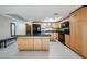 Bright kitchen with stainless steel appliances, tile floors, light wood cabinets, and a black island at 7860 E Camelback Rd # 309, Scottsdale, AZ 85251