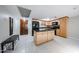 Spacious kitchen with a large island, black appliances, and light wood cabinets at 7860 E Camelback Rd # 309, Scottsdale, AZ 85251