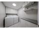 This laundry room features side-by-side washer and dryer, plenty of shelving and cabinet storage at 7860 E Camelback Rd # 309, Scottsdale, AZ 85251