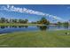 Beautiful view of a golf course pond with a fountain, surrounded by lush greenery and mature trees at 805 S 82Nd Pl, Mesa, AZ 85208