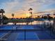 Outdoor pickleball court with lake views at sunset, complemented by palm trees and lush green landscapes at 805 S 82Nd Pl, Mesa, AZ 85208