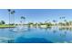 Peaceful view of a tranquil pond featuring a fountain and lush landscaping with swaying palm trees along the water's edge at 805 S 82Nd Pl, Mesa, AZ 85208