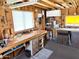 View of a spacious workshop with multiple workbenches, storage, and natural light for various projects at 805 S 82Nd Pl, Mesa, AZ 85208