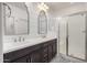 Modern bathroom featuring double sinks, stylish mirrors, and a glass-enclosed shower at 10657 E Texas Ave, Mesa, AZ 85212