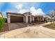 Charming single-story home with a brick driveway, manicured lawn, and a two-car garage at 10657 E Texas Ave, Mesa, AZ 85212