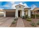 Inviting single-story home with a tile roof, brick walkway, and lovely landscaping at 10657 E Texas Ave, Mesa, AZ 85212