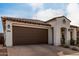 Single-story home with a brick driveway, two-car garage, and tile roof at 10657 E Texas Ave, Mesa, AZ 85212
