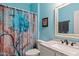 Bright bathroom with a blue floral shower curtain, framed mirror, and marble countertop at 10718 E Secret Canyon Rd, Gold Canyon, AZ 85118