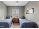 Well-lit bedroom with two twin beds, a nightstand, and a large window at 10718 E Secret Canyon Rd, Gold Canyon, AZ 85118