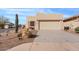 Tan single-story home featuring desert landscaping, a two-car garage and mature Saguaro cactus at 10718 E Secret Canyon Rd, Gold Canyon, AZ 85118