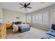 Bright main bedroom features a ceiling fan, shuttered windows, and a seating bench at 10718 E Secret Canyon Rd, Gold Canyon, AZ 85118