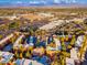 Aerial view of a property with orange stucco buildings, mature trees, pool, and mountain views at 12212 N Paradise Village S Pkwy # 129, Phoenix, AZ 85032