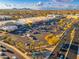 Aerial view of a shopping center with many parking spots available and mountains in the background at 12212 N Paradise Vlg S Pkwy # 129, Phoenix, AZ 85032