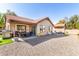 Wide shot of the gravel backyard with a covered patio, grill, seating and the home's exterior at 1344 W Seascape Dr, Gilbert, AZ 85233