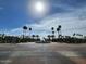 Elegant community entrance with lush palm trees and a central water fountain under a sunny, blue sky at 1344 W Seascape Dr, Gilbert, AZ 85233