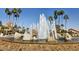 Community water feature with a stone-covered base and towering palm trees in the background at 1344 W Seascape Dr, Gilbert, AZ 85233