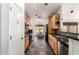 Long, galley-style kitchen with wood cabinets, black appliances, modern tile backsplash, and checkered tile flooring at 1344 W Seascape Dr, Gilbert, AZ 85233