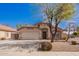 Charming single-story home with a two-car garage, xeriscaped front yard and mature shade tree at 14105 N 157Th Ct, Surprise, AZ 85379