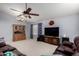 Spacious living room featuring a ceiling fan, chandelier, large TV, and comfortable leather furniture at 1412 E Erie St, Chandler, AZ 85225