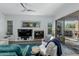 Cozy living room featuring a fireplace, ceiling fan, and sliding glass doors to the outdoor pool area at 14741 E Mountain Majesty --, Fountain Hills, AZ 85268