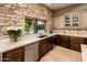 Gourmet kitchen showcasing stone wall accents and quartz countertops, with a view of the backyard pool at 1516 W Port Au Prince Ln, Phoenix, AZ 85023